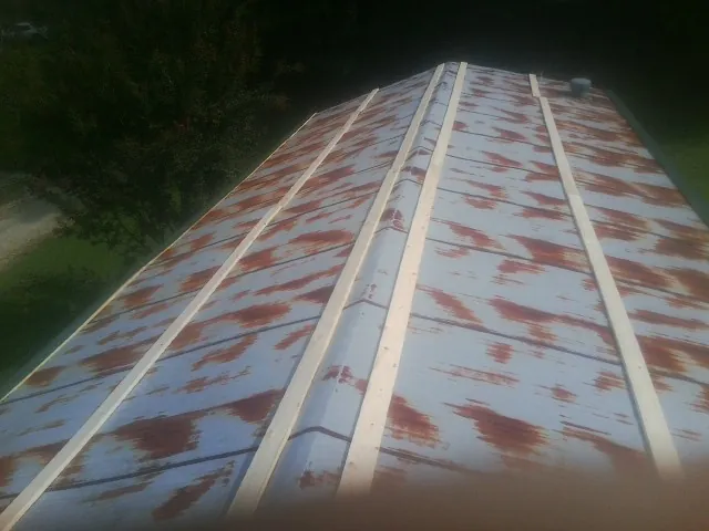 Rusted metal roof panels with new wood purlins before replacement — Storm Damage Roof Repair in Sabattus by Roofing Brothers