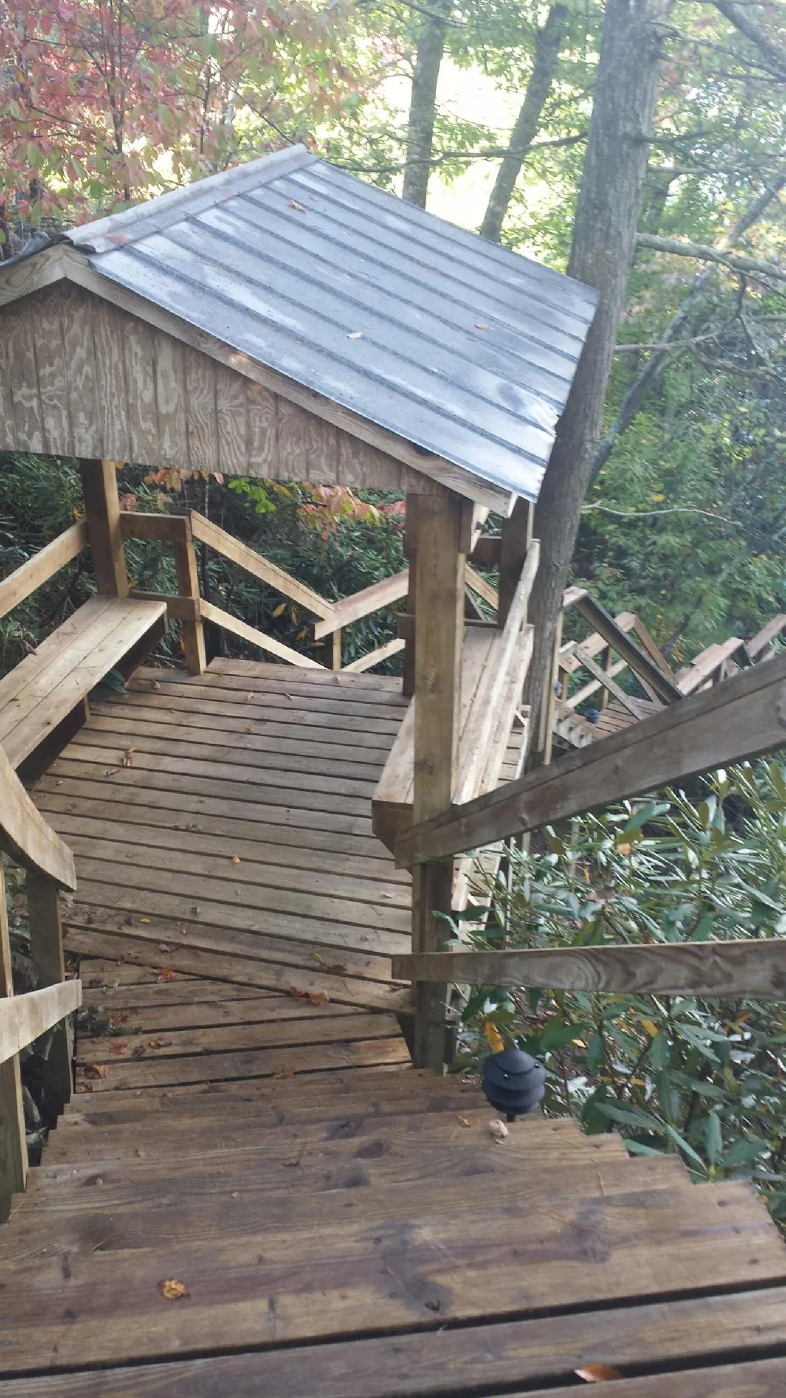 Metal roofed shelter over wooden steps on a wooded walkway — Skylight Repair & Installation work by our crew in Sabattus